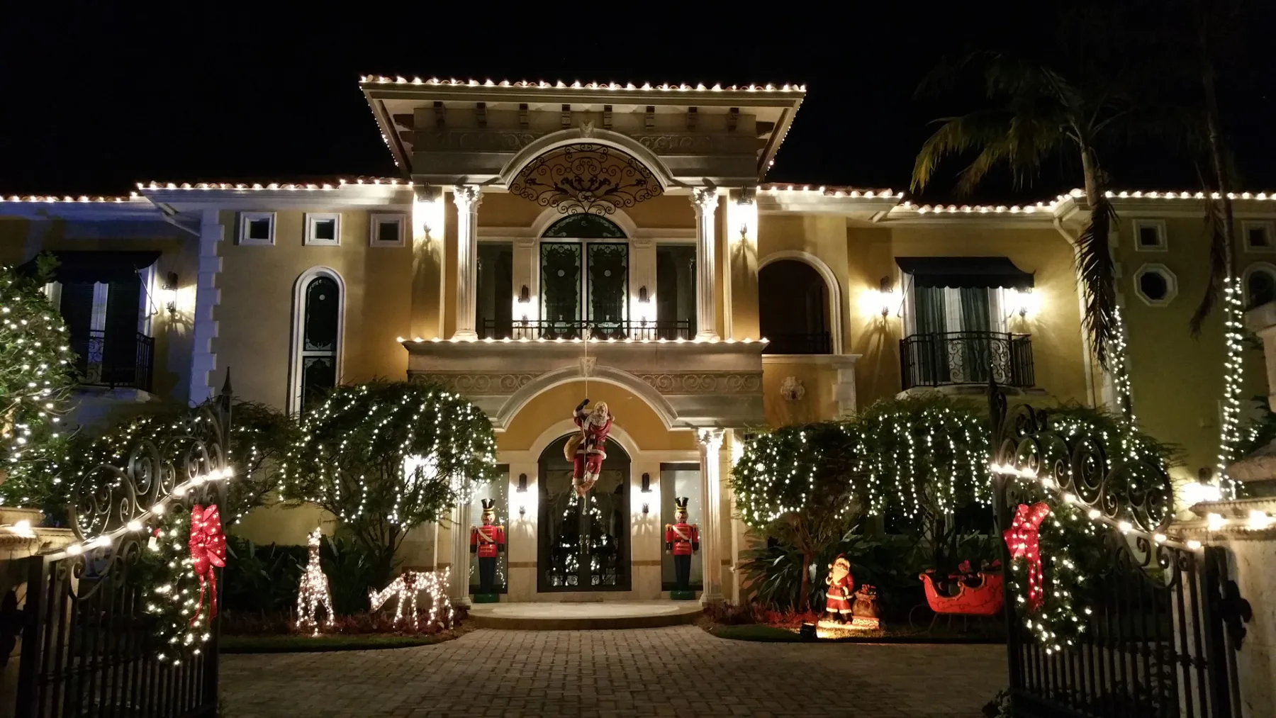 Two-story home with roofline and landscape holiday lighting