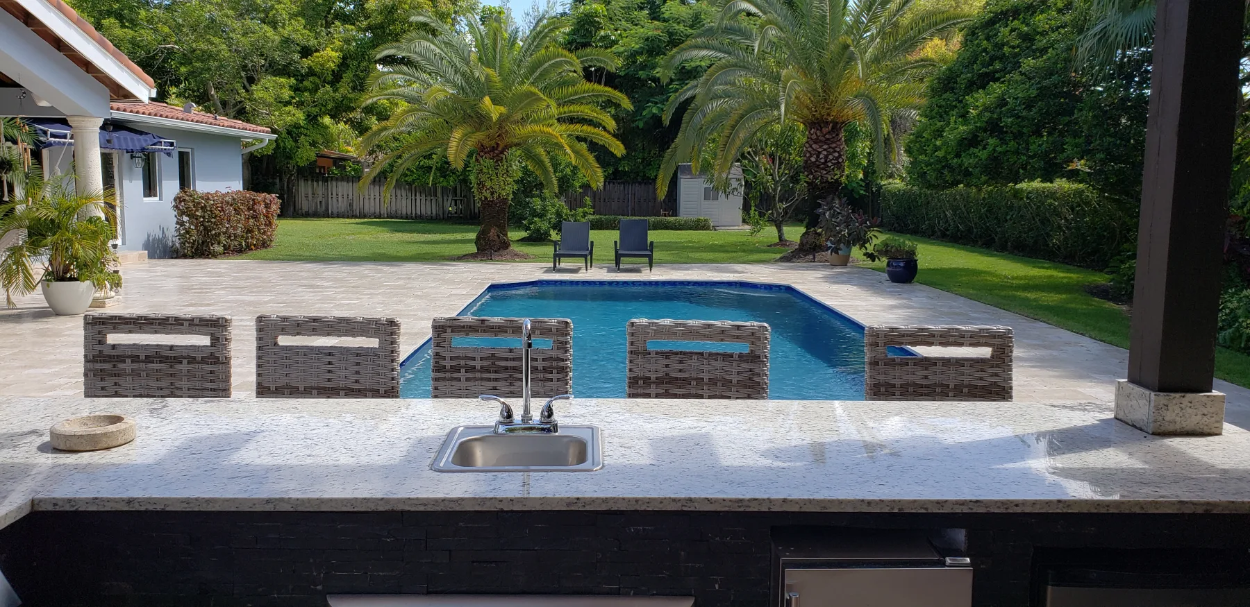 View across a poolside kitchen toward the patio and garden