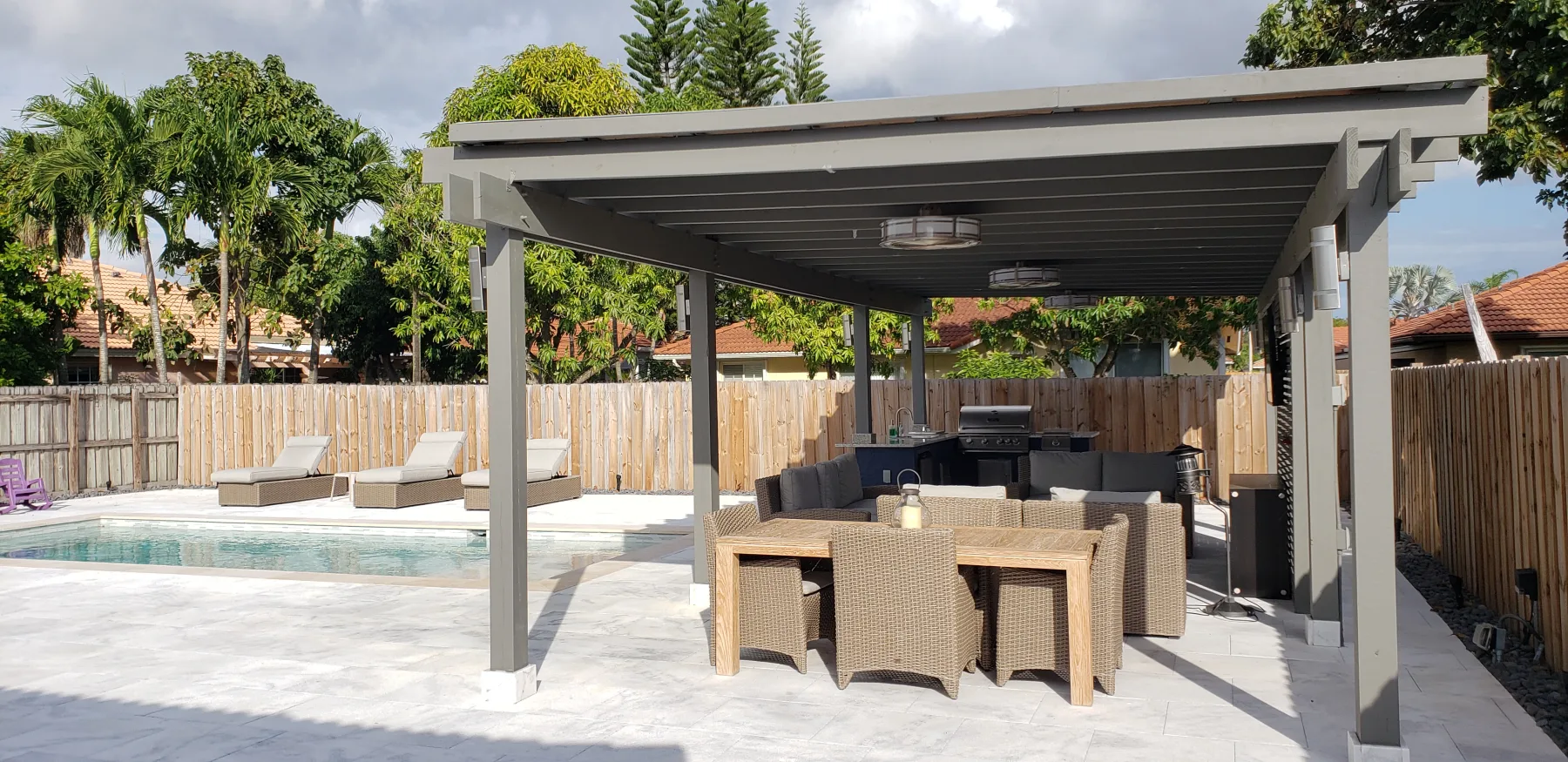 Covered dining and kitchen area beside the backyard pool