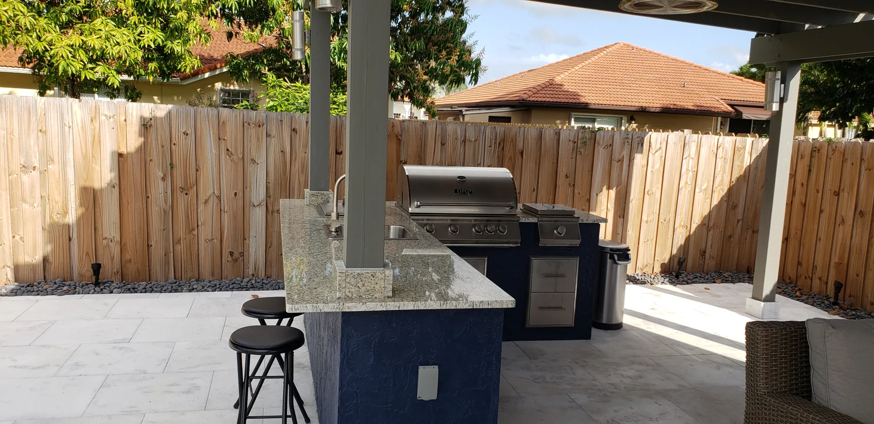 Built-in grill and counter beneath the poolside pergola