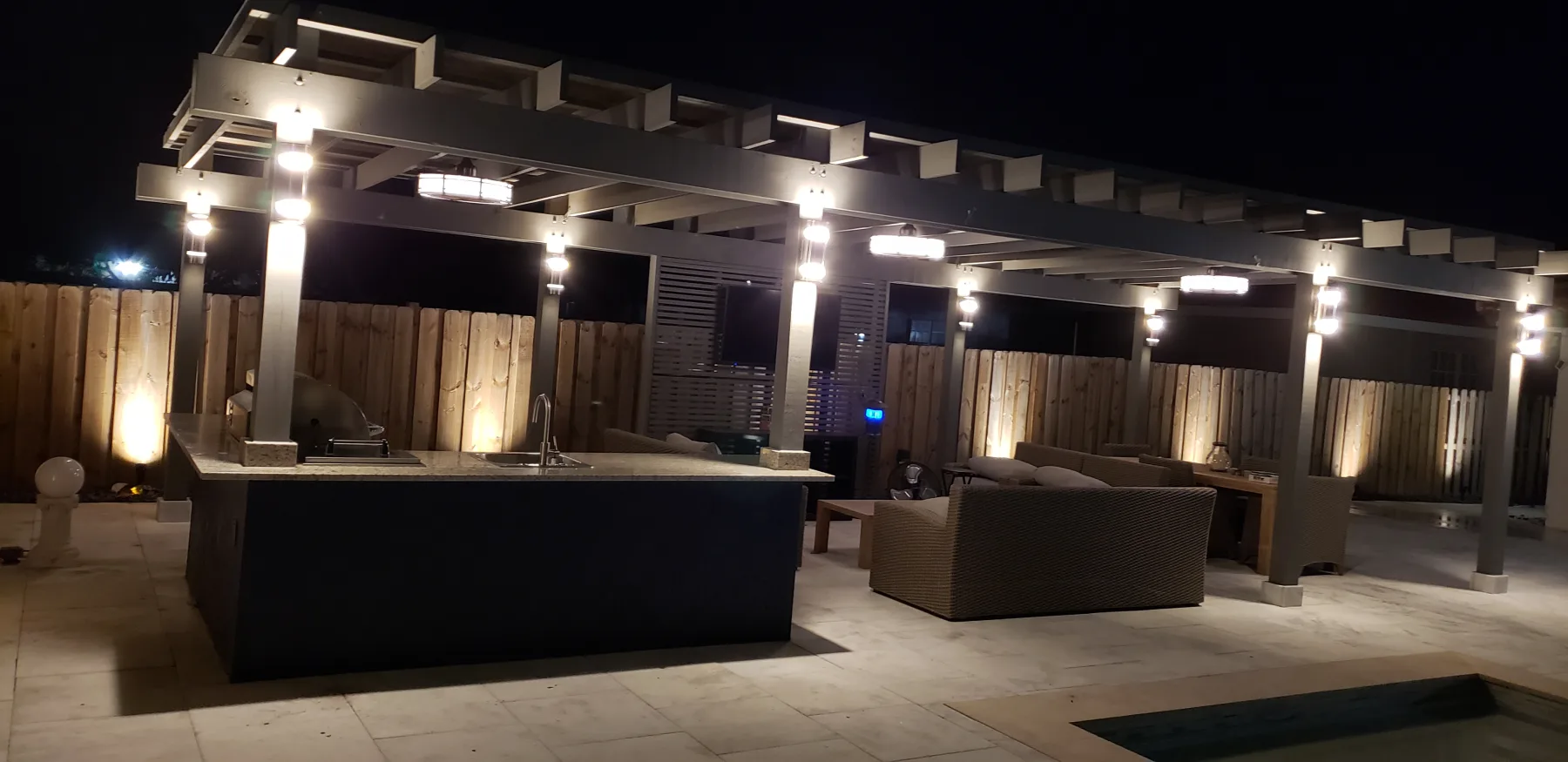 Pergola and outdoor seating illuminated after dark