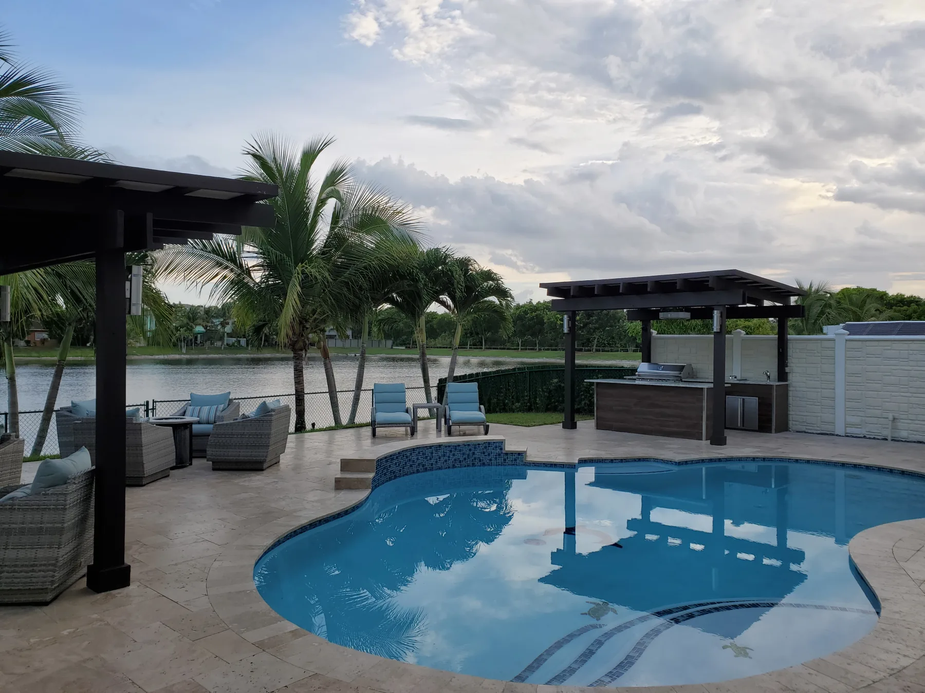 Curved pool with pergola and outdoor lounge seating