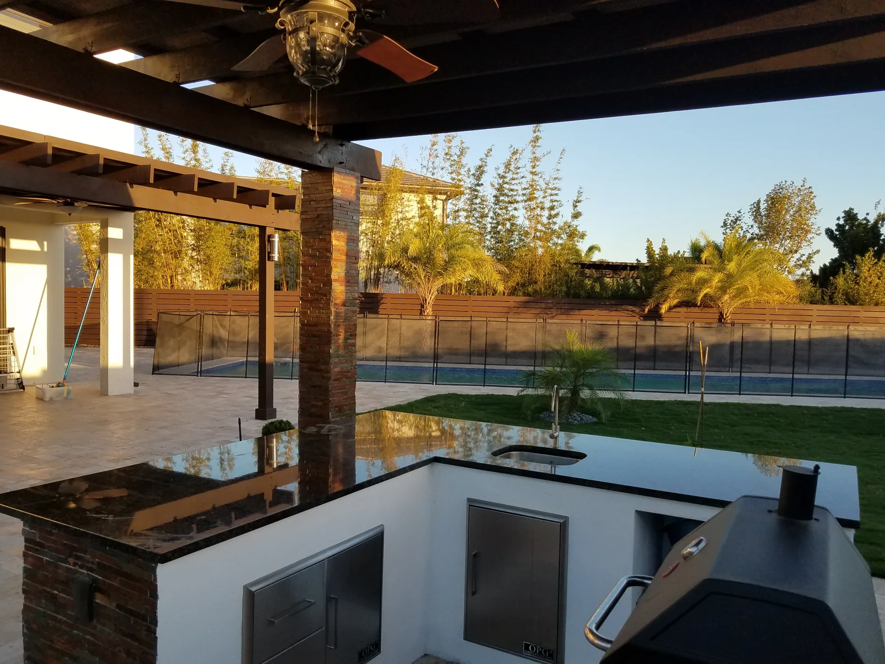 View from the outdoor kitchen beneath a wooden pergola