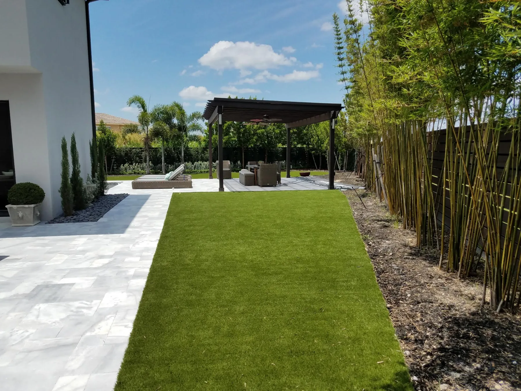 Synthetic turf lawn beside a poolside pergola